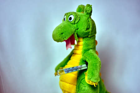 Plush toy dinosaur with a traditional thermometer
の写真素材