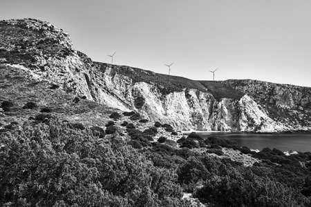 rocky coast and windmills on a hill on the island of Kefalonia in Greece, monochrome