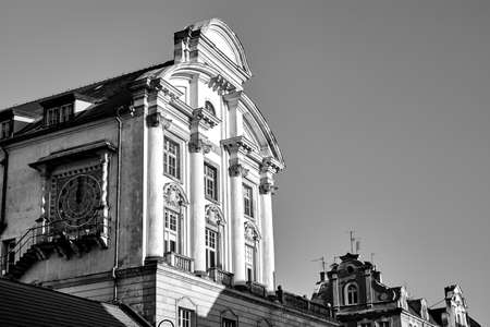 The facade of a historic tenement house with a clock in Poznan, monochrome