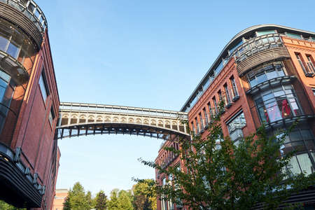 a metal footbridge and a historic old red brick brewery in Poznanの写真素材