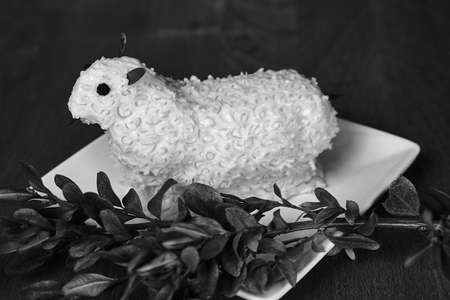 Traditional Easter lamb made of butter on a white plate in Poland, monochrome