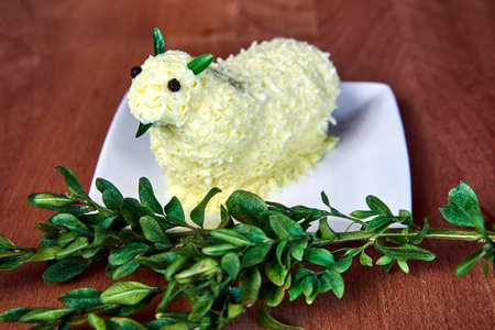 Traditional Easter lamb made of butter and boxwood twigs on wooden table in Polandの写真素材