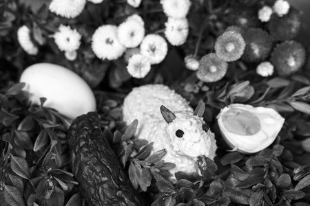 Traditional Easter lamb made of butter, boxwood twigs and colorful spring flowers in Poland, monochromeの写真素材