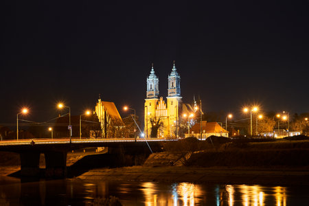bridge over the river Warta and gothic cathedral at night in Poznan in Polandの写真素材