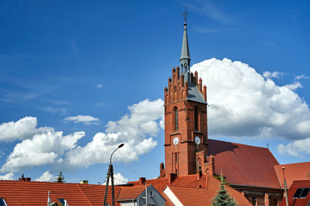 roofs made of red tiles and the bell tower of the historic gothic church in the village of Bledzew, Polandの写真素材