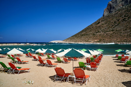 Umbrellas and sunbeds on the sandy beach in Stavros on the island of Crete, greece