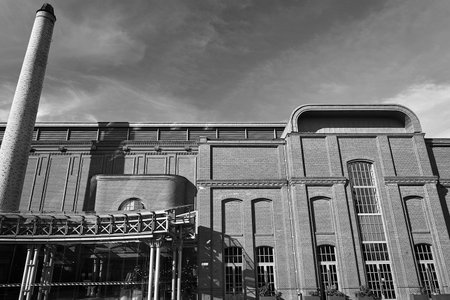 Chimney and building of renovated old brewery in the city of Poznan, Poland, monochrome