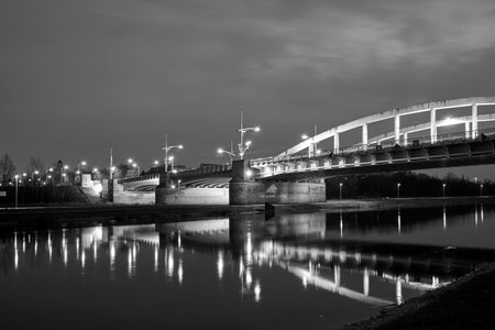The steel structure of the road bridge over the Warta River during the night in the city of Poznan, Poland, monochromeの写真素材
