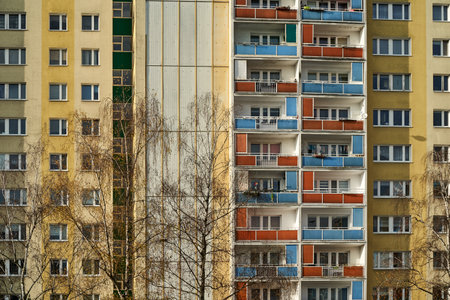 Tree branches in front of the facade with balconies of a residential high-rise building in Poznan, Polandの写真素材