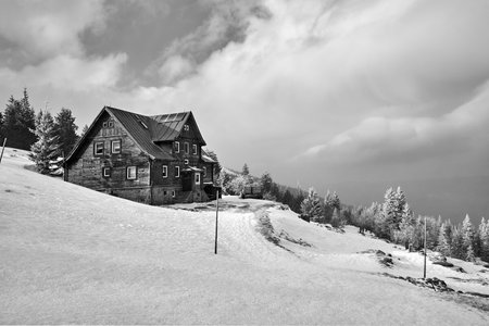 Wooden house on the slope of Labski Peak in winter in the Karkonosze mountains, Poland, monochromeの写真素材