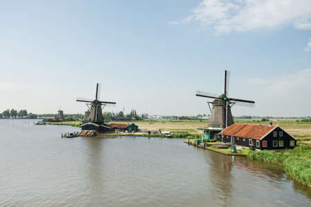 Traditional windmill near the river at Zaanse Schans, Hollandの写真素材