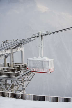 Frozen red funcular cabin arrieved to the end station covered with snow, Alps, Franceのeditorial素材