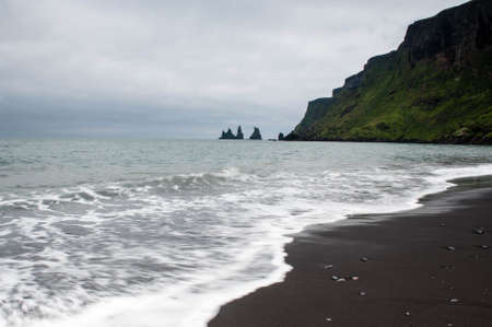 Famous cliffs and the black sand beach on a cloudy day near VÃ­k Ã­ MÃ½rdal, South Iceland