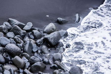 Rocks on the black sand and sea waves captured from above near VÃ­k Ã­ MÃ½rdal, South Icelandの写真素材