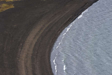 View of the black sand beach and blue water from above, Icelandの写真素材