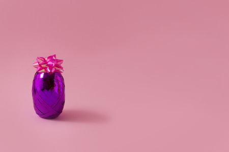 A creative original composition of a gift ribbon and a bow is located in the center of the picture in the form of pineapple.の写真素材