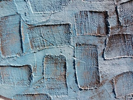 Blue real texture of plaster background with areas of rectangular depressions, which can be used to...