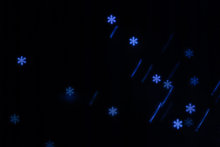 Beautiful figured boke from a garland of cold light in the form of a snowflake on a dark background....
