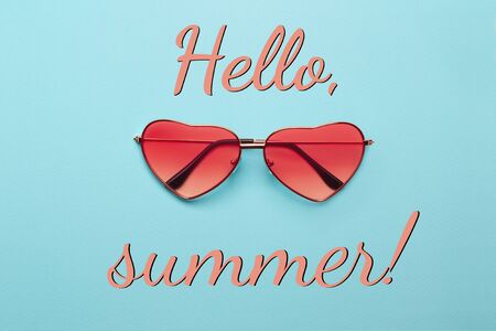 Trend photo on the theme of fashionable orange hue this season. Bright orange heart-shaped glasses on a turquoise paper background.の写真素材