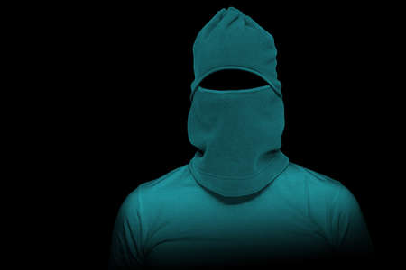 Thief with green mask on his face on black background.の写真素材