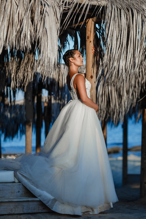 Beautiful smiling young bride and groom walking on the beach, kissing and having fun, wedding ceremony near the rocks and sea. Wedding ceremony on coast of Cyprusの写真素材