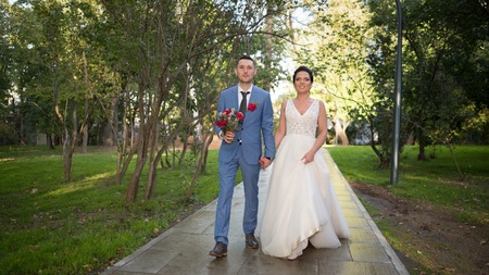 Wedding couple on the nature is hugging each other. Beautiful model girl in white dress. Man in suit. Beauty bride with groom. Female and male portrait. Woman with lace veil. Lady and guy outdoorsの写真素材