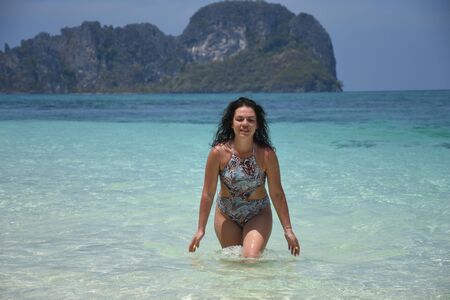 Beautiful brunette relaxes on the azure shore of the island in Thailandの写真素材