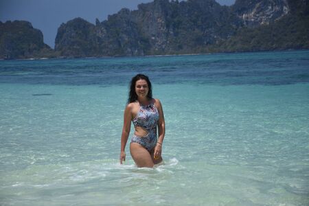 Beautiful brunette relaxes on the azure shore of the island in Thailandの写真素材