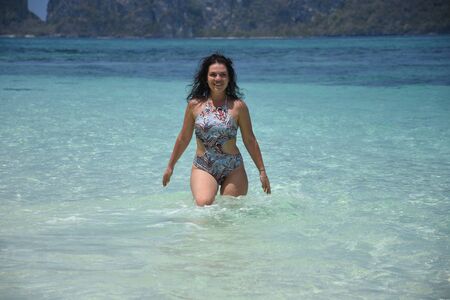 Beautiful brunette relaxes on the azure shore of the island in Thailandの写真素材
