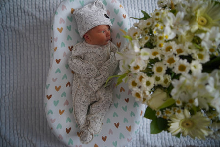 Newborn baby surrounded by beautiful flowersの写真素材