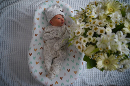 Newborn baby surrounded by beautiful flowersの写真素材