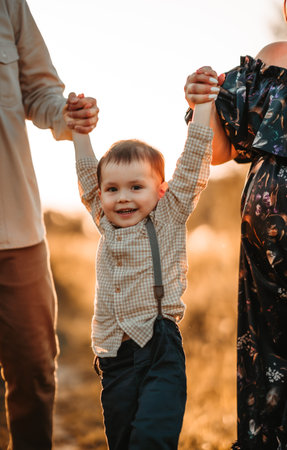 A little two-year-old boy in a field with tall grassの写真素材