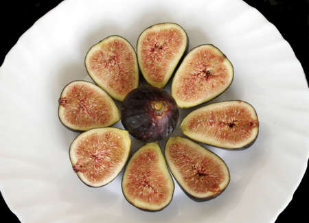 Sliced ripe figs on the plate in isolated over black