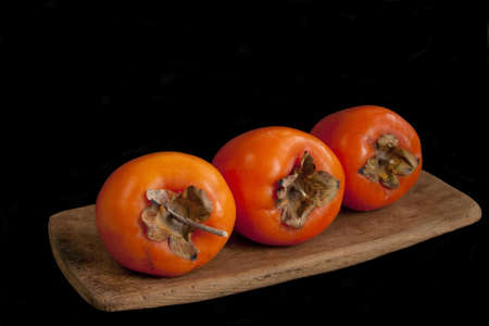 Fresh ripe persimmon isolated on black backgroundの写真素材