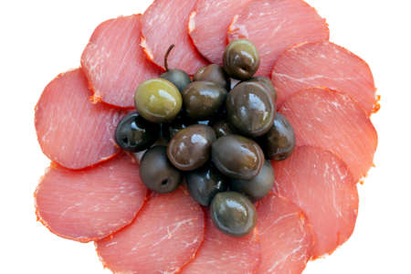 Some slices of cured pork loin and olives isolated on white