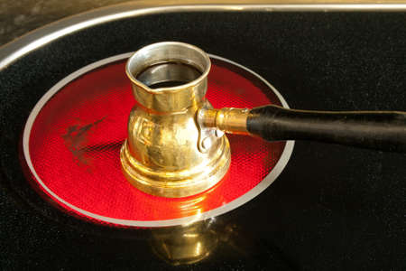 Arab cooper coffee pot on red hot ceramic stoveの写真素材