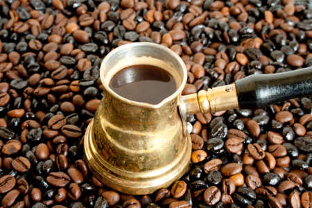 Arab small coffee pot on coffee-beans backgroundの写真素材