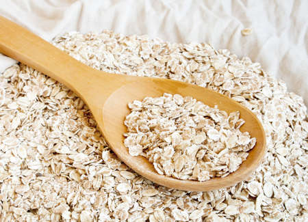 Dry rolled oats in wooden spoonの写真素材