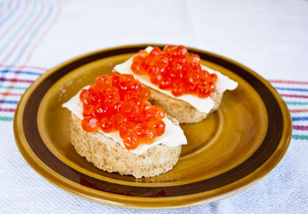 Red caviar sandwich on small ceramic plateの写真素材