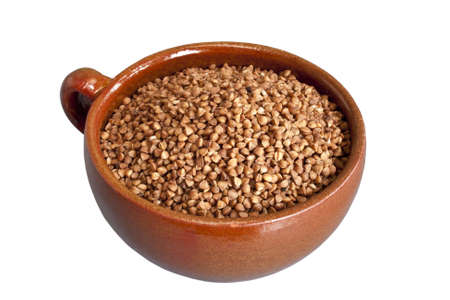Dry buckwheat in ceramic bowl over white backgroundの写真素材