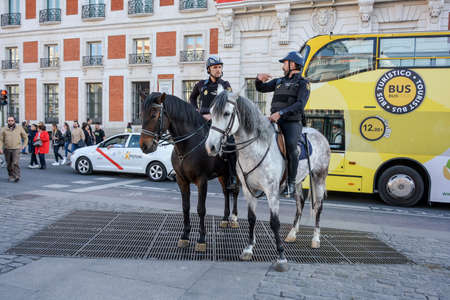 Madrid, Spain-24 February 2019: Police on horses are watching and helping people en the squareのeditorial素材