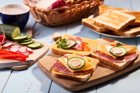 Breakfast with a toasted bread, sausage and cheese and a cap of cocoaの写真素材