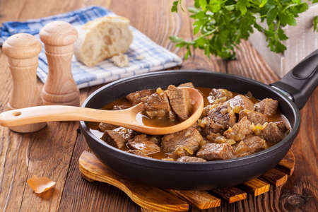 Preparing beef stew - wooden backgroundの写真素材