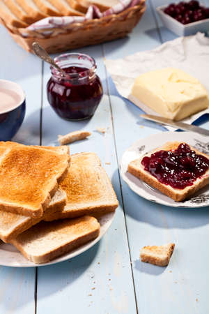 Breakfast with bread toast with cherry jam and a cup of cocoaの写真素材