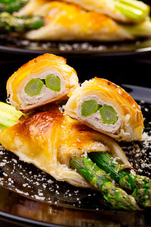 Asparagus baked in puff pastry served on black plateの写真素材