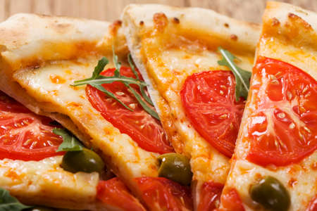 Pizza vegetarian on plate on stone black try with fresh tomatoes and olivesの写真素材