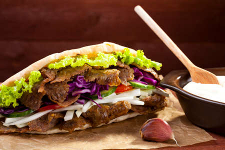 Beef Kebab in a bun with garlic sauce on woodboardの写真素材