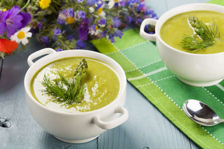 Delicious soup with asparagus, served in white bowls.の写真素材