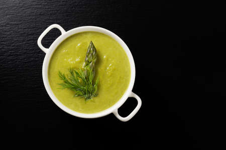 Delicious soup with asparagus, served in white bowls.の写真素材