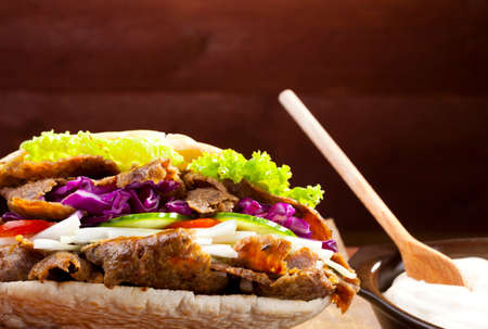 Beef Kebab in a bun with garlic sauce on woodboardの写真素材